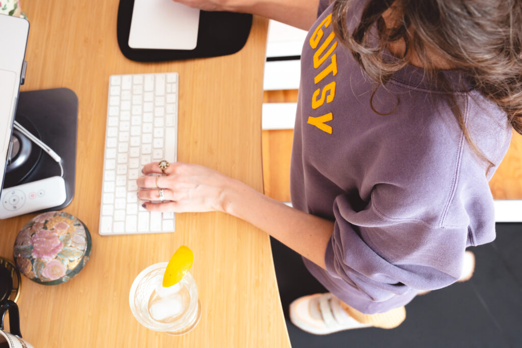 Overhead shot of copywriter and messaging strategist Cassie Paton working at her desktop while standing on a walking pad.