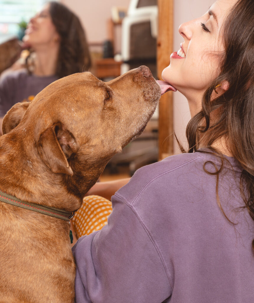 Copywriter Cassie Paton and her dog, Rocco, who is giving her a kiss.